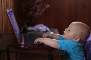 Toddler sitting in front of laptop