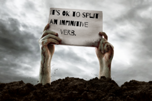 Zombie hands holding a sign that says It's OK to split an infinitive verb
